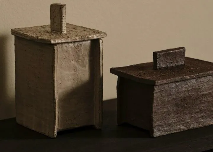 Zwei kunstvoll unregelmäßige, rechteckige Aufbewahrungsboxen aus grober, strukturierter Keramik mit passenden Deckeln und Griffen von Ferm Living im Wabi-Sabi-Stil.