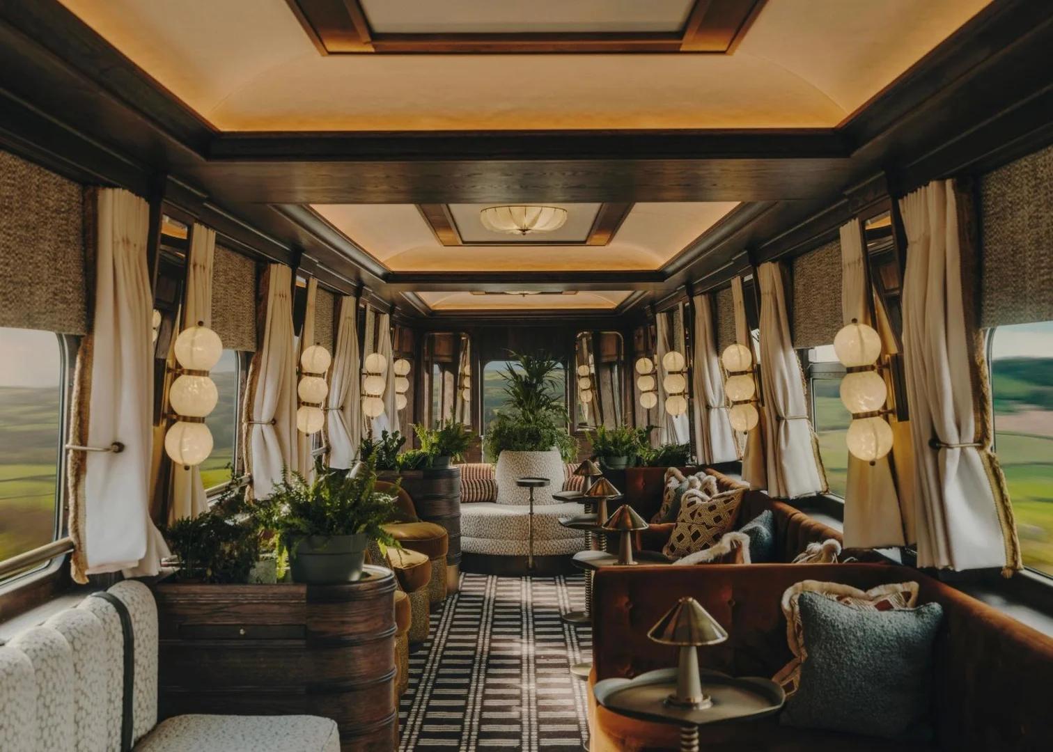Belmond Britannic Explorer: Elegantes Interior im Luxuszug Elegantes Interieur des Belmond Britannic Explorer mit Sitzbereichen, Pflanzen und großen Fenstern mit Landschaftsblick