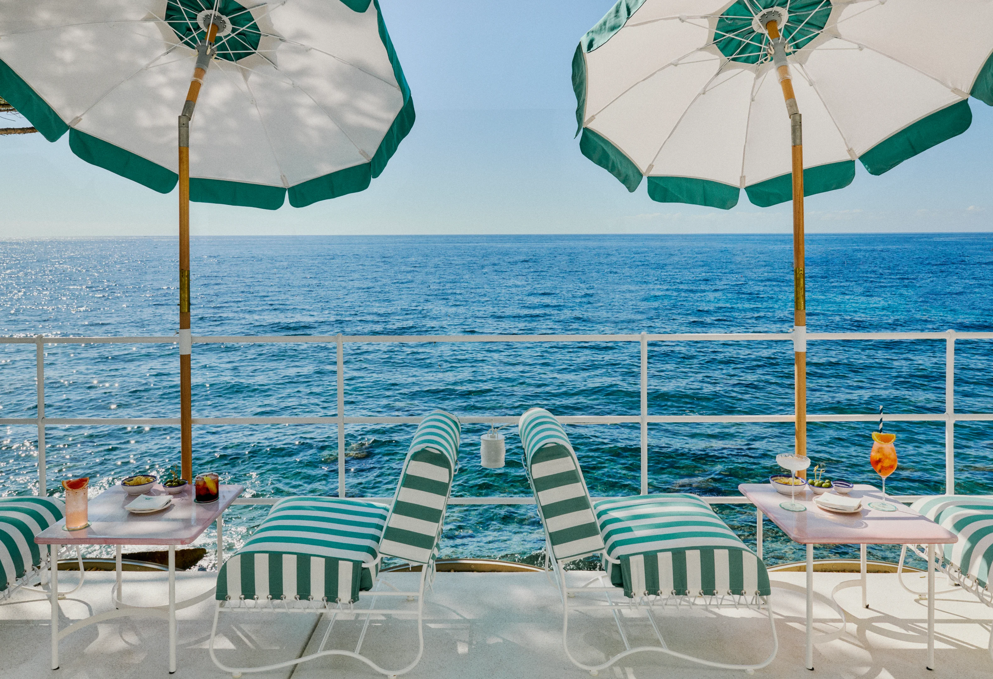Gestreifte Sonnenliegen im Beach Club des Hotels Le Sirenuse mit Blick auf das Meer vor Positano.