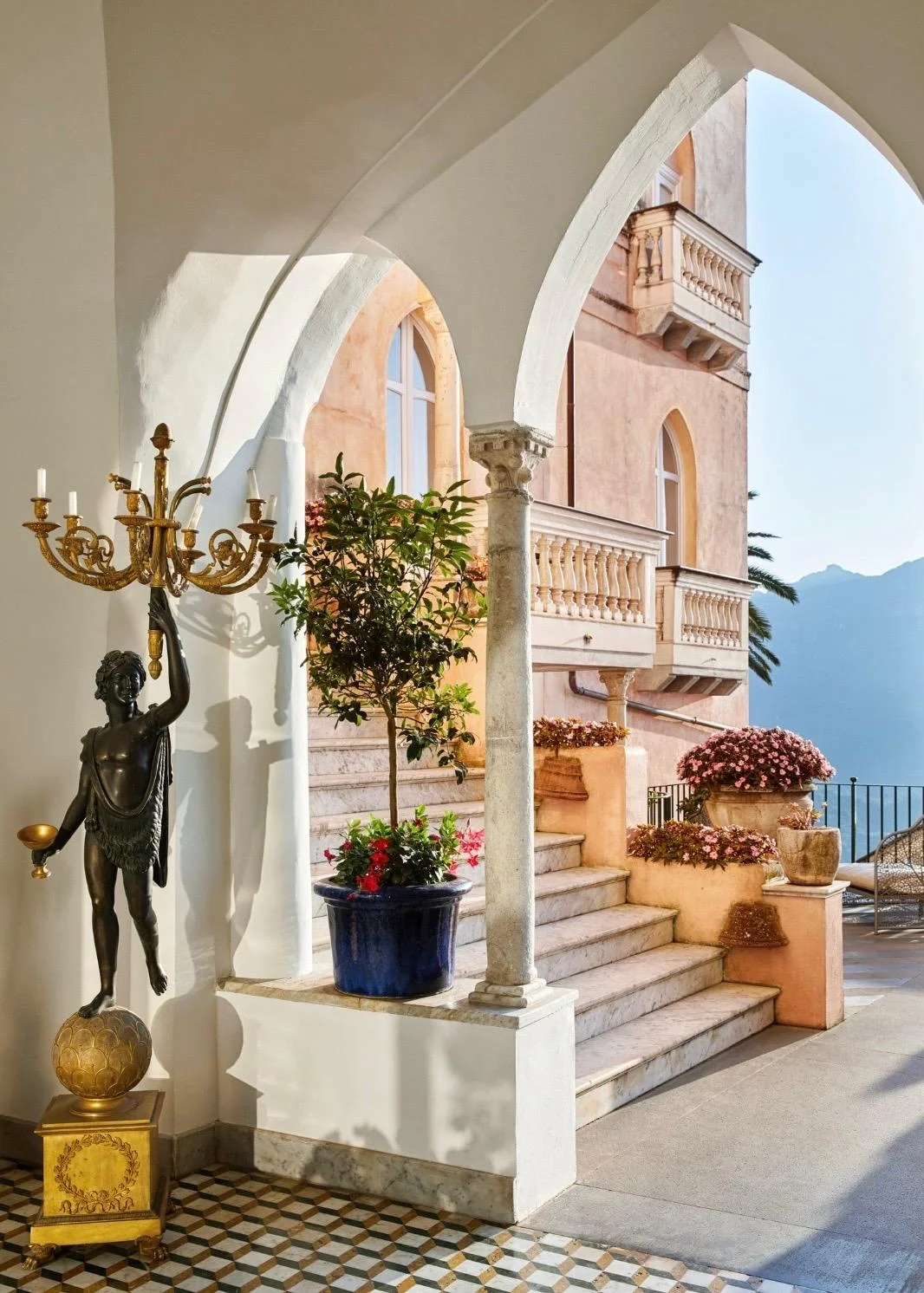 Statue vor dem Palazzo Avino in Ravello mit rosafarbener Fassade und Blick auf die Amalfiküste.